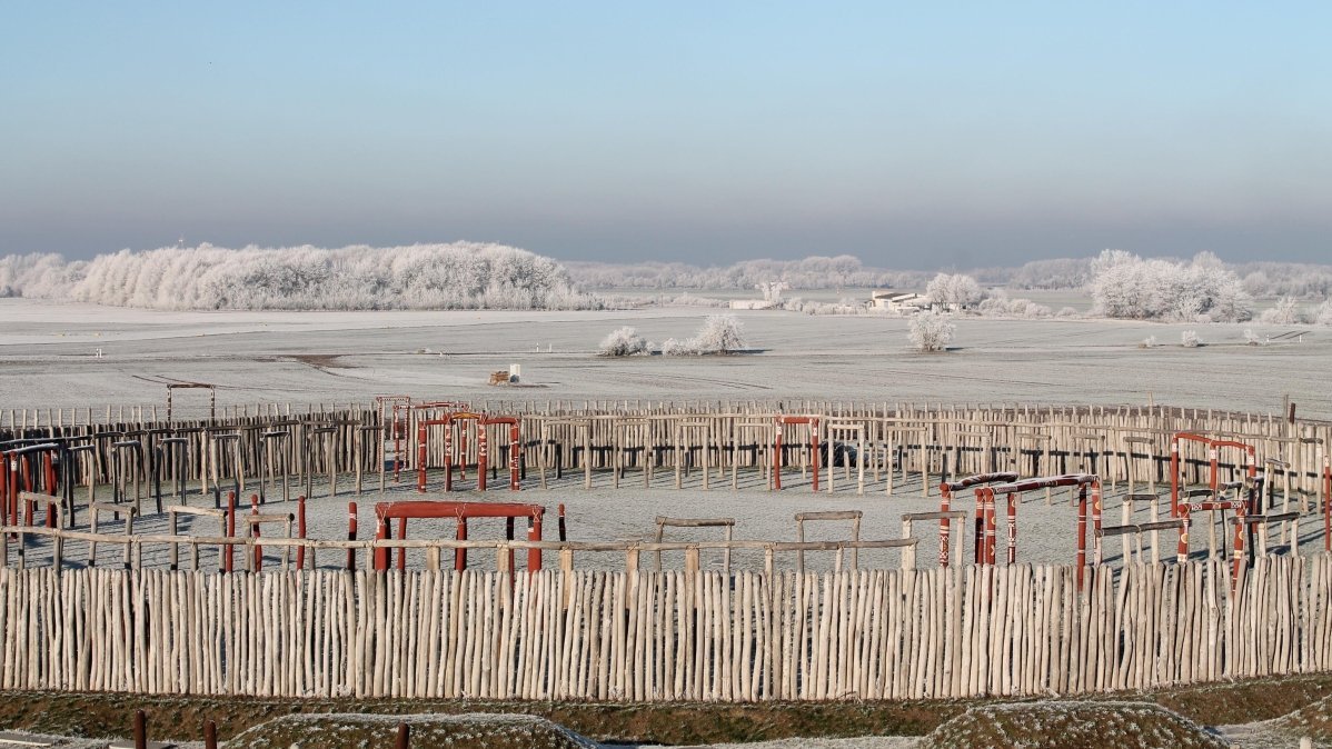 Das rekonstruierte Ringheiligtum von Pömmelte im Winter. Es war ein zentraler Ort vom Ende der Steinzeit bis zum Beginn der Bronzezeit mit überregionaler Bedeutung. Zeitstellung, Grundriss und Bedeutung entsprechen der gleichzeitigen Anlage von Stonehenge, das in seinen frühen Phasen wahrscheinlich auch aus Holz bestand. © SLK Salzlandmuseum, Stephan Knopf.